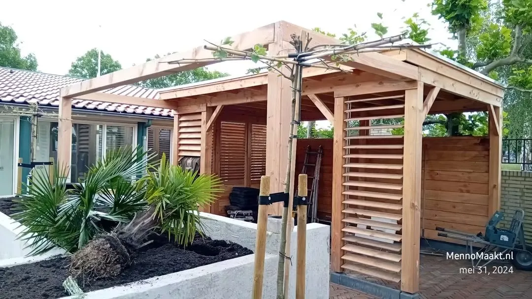 Prachtige maatwerk overkapping en vlonder in een groene tuin in Delft